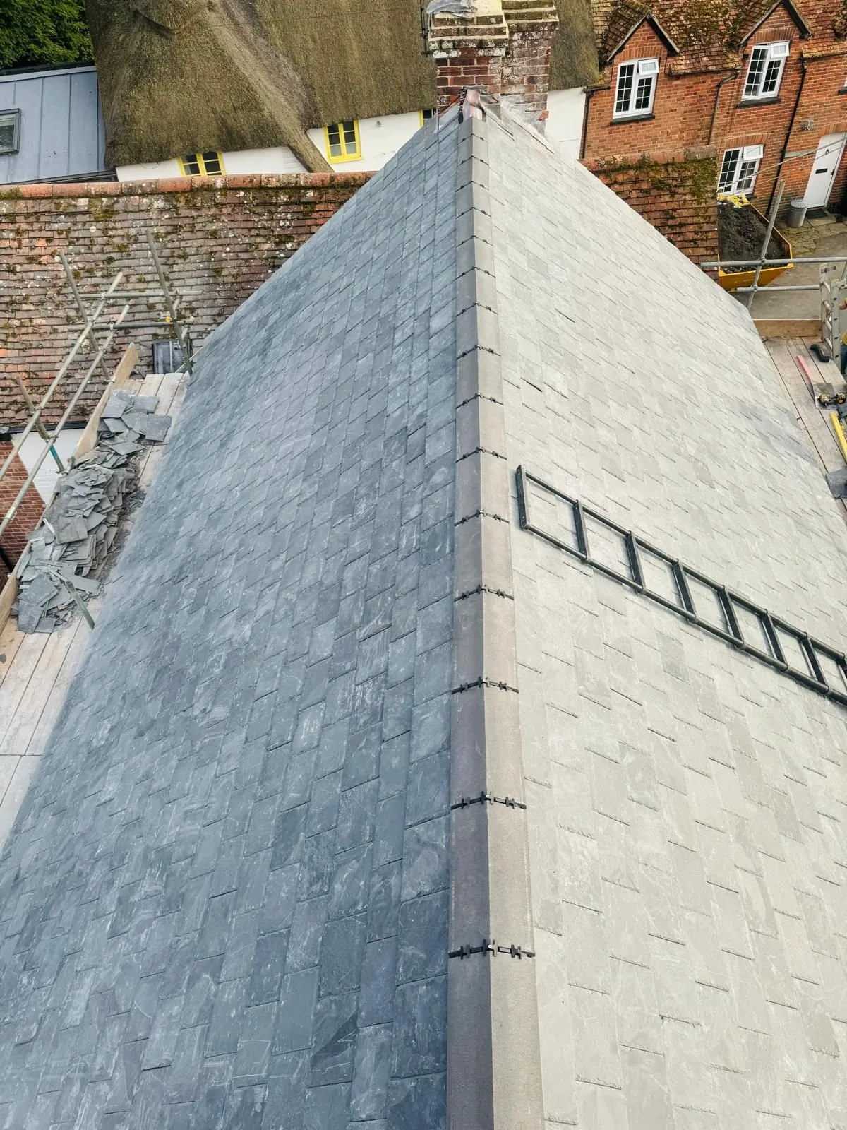 Natural slate re-roof with a newly finished ridge and scaffold in place