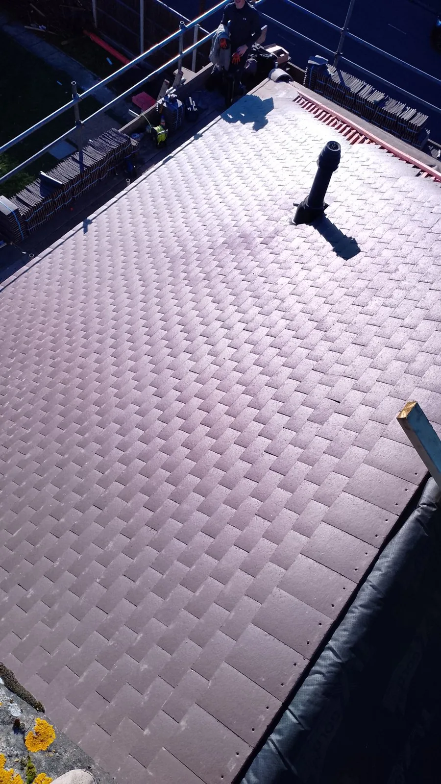 New clay plain-tile roof with a fitted roof vent and scaffold in place
